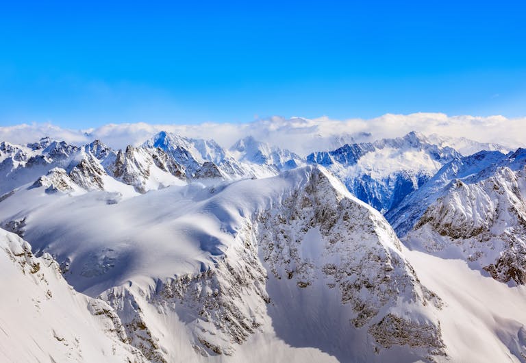 Areal Photography Of Snow Coated Mountains Under Clear Blue Sky