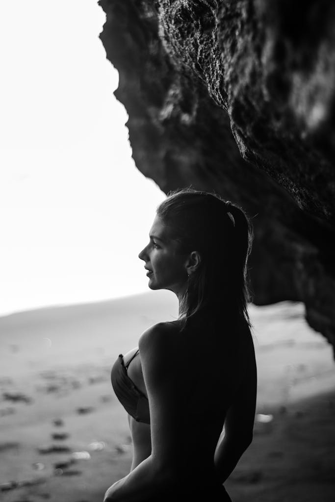 Silhouette of Woman in Cave by the Beach