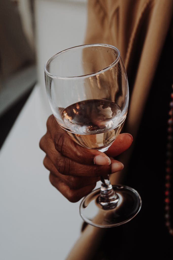 A detailed view of a hand holding a wine glass, captured in Lyon, France.