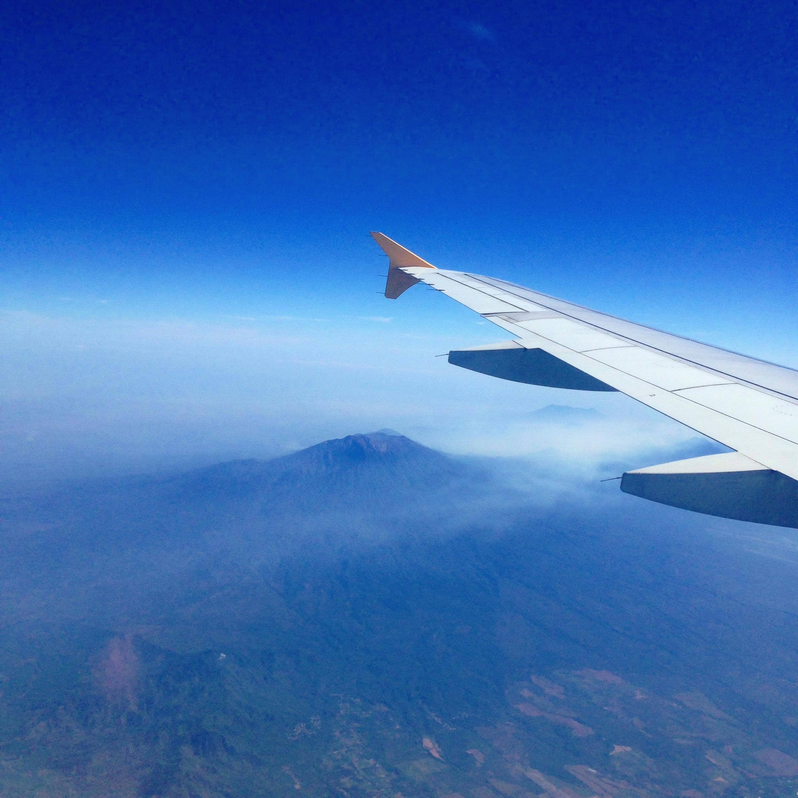 A stunning aerial view of a mountain from an airplane window over Singapore.